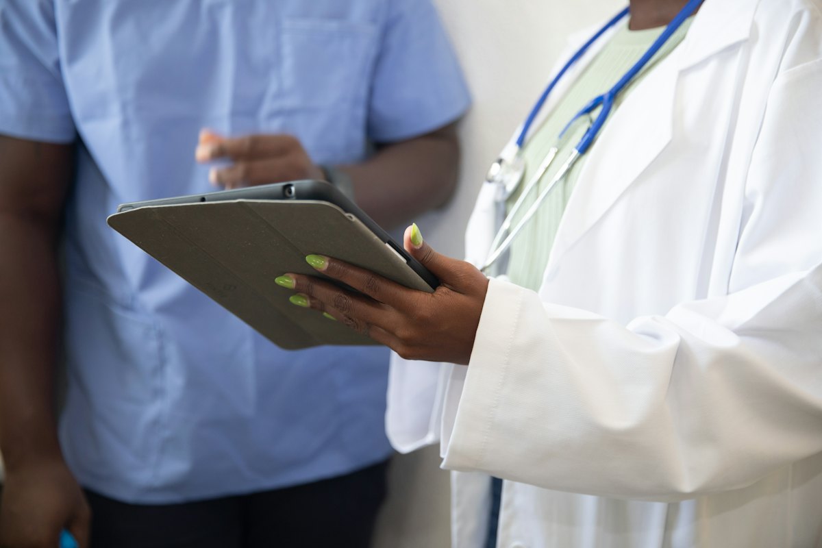 Ärztin zeigt einem Patienten etwas auf dem Tablet
